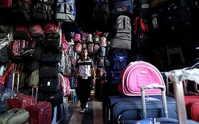 A Syrian man looks at backpacks and suitcases for sale at a market in Damascus on September 22, 2015. When customers ask which of the backpacks displayed in the Souk al-Khija market is the sturdiest, the shopkeeper knows they are planning to take to the sea to reach Germany. (AFP/LOUAI BESHARA)