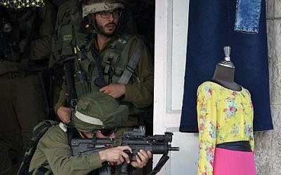 Israeli soldiers confront Palestinian protesters in the West Bank city of Hebron on September 23, 2015 (Hazem Bader/AFP)