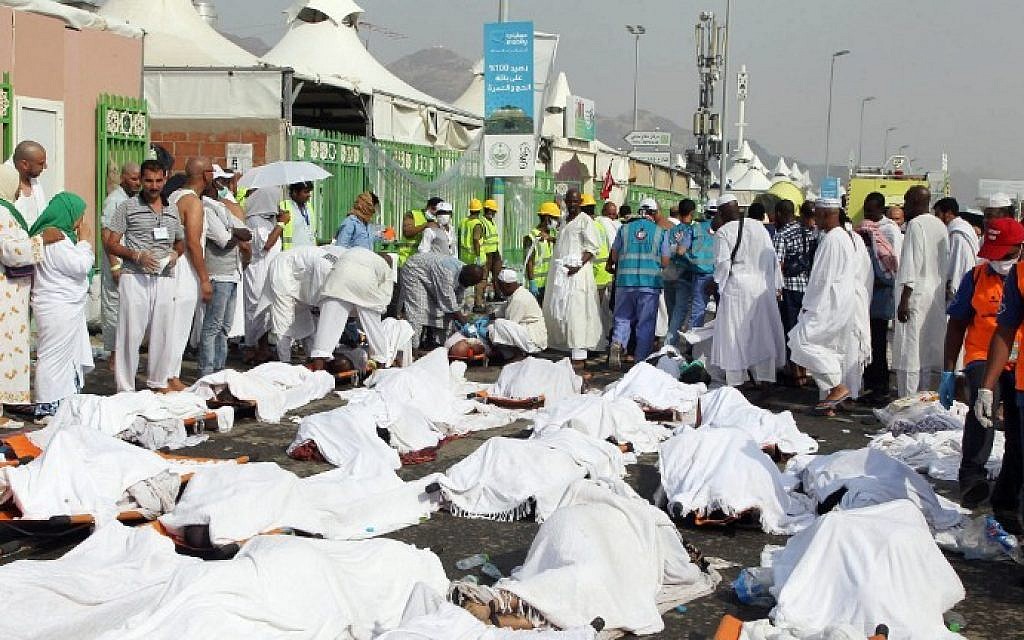 Saudi emergency personnel stand near bodies of Hajj pilgrims at the site where at least 717 were killed and hundreds wounded in a stampede in Mina, near the city of Mecca, at the annual hajj in Saudi Arabia on September 24, 2015. (STR/AFP)