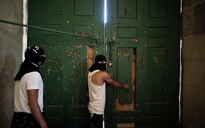 Masked Palestinians secure the door of the al-Aqsa Mosque on September 27, 2015. (AFP PHOTO/AHMAD GHARABLI)
