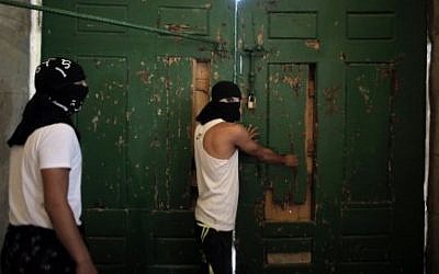 File: Masked Palestinians secure the door of Jerusalem's al-Aqsa Mosque on September 27, 2015, as they plan to remain inside to protect it in case of clashes. (AFP/AHMAD GHARABLI)