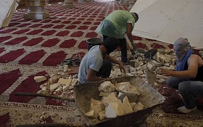 Masked Palestinians prepare stones inside Jerusalem's Al-Aqsa Mosque, one of Islam's holiest sites, on September 27, 2015. (AFP PHOTO/AHMAD GHARABLI)