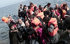 Syrian refugees land on the shores of the Greek island of Lesbos in an inflatable dingy across the Aegean Sea from Turkey on September 3, 2015. (AFP/Angelos Tzortzinis)