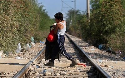 A migrant child crosses the Greek-Macedonian border near the vilage of Idomeni, northern Greece, on September 4, 2015. (AFP/Sakis Mitrolidis)
