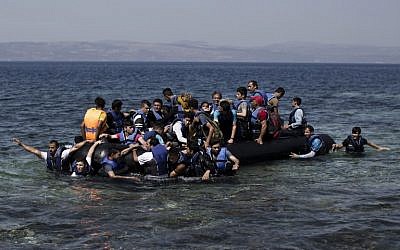Syrian refugees arrive on the shores of the Greek island of Lesbos after crossing the Aegean Sea from Turkey on a inflatable dinghy, September 11, 2015. (AFP/ANGELOS TZORTZINIS)