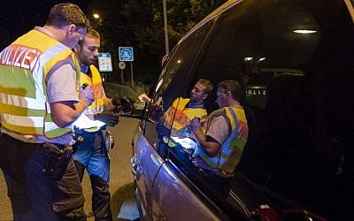 German police officers check a car from Hungary on September 13, 2015, in the southern German city of Freilassing at the border between Germany and Austria, after Berlin's shock decision to reintroduce such controls to halt a surge in refugee numbers. (AFP/ GUENTER SCHIFFMANN)