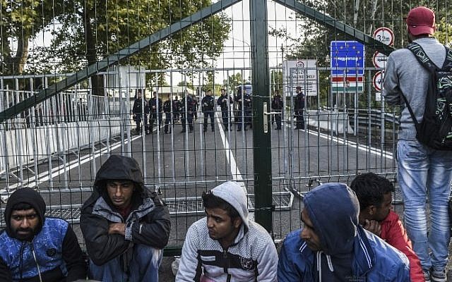 A refugee stands looking through the fence at the Serbian border with Hungary near the town of Horgos, on September 15, 2015. (AFP PHOTO/ARMEND NIMANI)