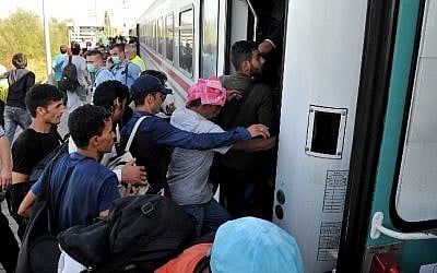 Migrants and refugees board a train at the railway station in the village of Ilaca, near the  Eastern-Croatian town of Tovarnik in the region of the official border crossing between Serbia and Croatia, on September 17, 2015.  (Elvis Barukcic/AFP)