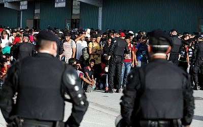 Croatian police stand guard as migrants and refugees gather in Zagreb's Fair Convention center,  on September 18, 2015. (AFP PHOTO/STR)