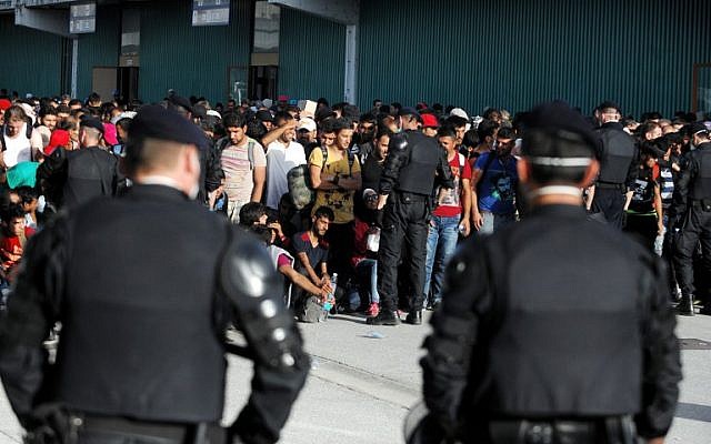 Croatian police stand guard as migrants and refugees gather in Zagreb's Fair Convention center, on September 18, 2015. (AFP PHOTO/STR) Croatian police stand guard as migrants and refugees gather in Zagreb's Fair Convention center, on September 18, 2015. (AFP PHOTO/STR)