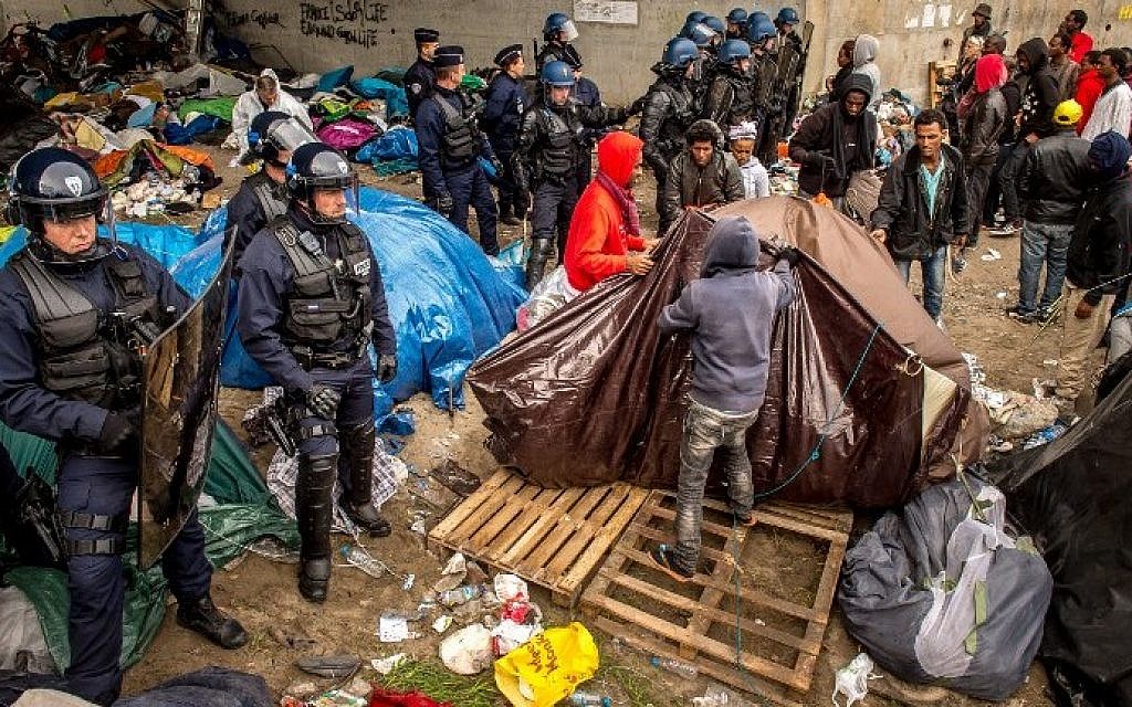 French gendarmes stand guard during the eviction of migrants from a camp site in Calais, northern France, on September 21, 2015. (AFP/ PHILIPPE HUGUEN)