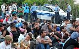 Migrants and refugees wait for a bus to be taken to the Croatian-Hungarian border in the Serbian-Croatian border village of Bapska, near the eastern Croatian town of Ilok, on September 23, 2015.  (AFP/ ELVIS BARUKCIC)
