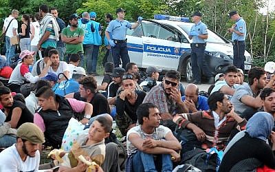 Migrants and refugees wait for a bus to be taken to the Croatian-Hungarian border in the Serbian-Croatian border village of Bapska, near the eastern Croatian town of Ilok, on September 23, 2015.  (AFP/ ELVIS BARUKCIC)