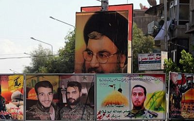 File: A file picture taken on September 21, 2015 shows a portrait of Hassan Nasrallah (top), the head of Lebanon's militant Shiite Muslim movement Hezbollah, and portraits of pro-government force members killed in combat displayed on a street in the Syrian capital, Damascus. (AFP PHOTO/JOSEPH EID)