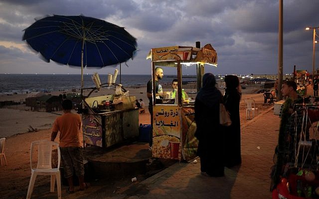 A picture taken on September 2, 2015 shows Gaza City's well known street vendor Mohammed Abu Assi, selling corn at the sea side promenade. Mohammed Abu Assi spent several days in a coma after swallowing poison. (Photo by AFP Photo / Mohammed Abed)
