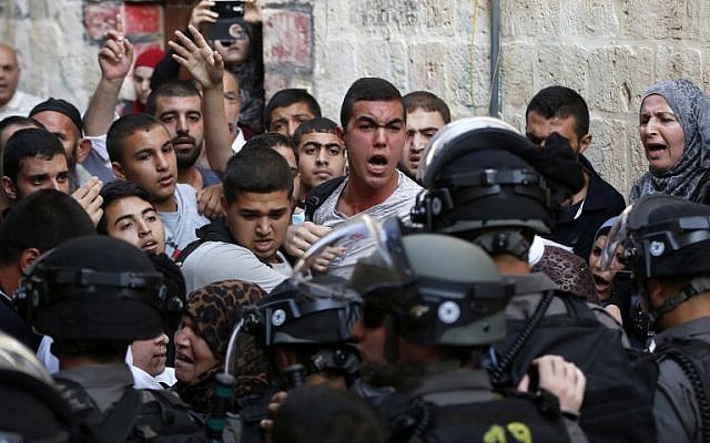 Palestinians shout in front of Israeli security forces who block a road leading to the Al-Aqsa mosque compound in Jerusalem's Old City on September 13, 2015. (AFP PHOTO / AHMAD GHARABLI) Palestinians shout in front of Israeli security forces who block a road leading to the Al-Aqsa mosque compound in Jerusalem's Old City on September 13, 2015. (AFP PHOTO / AHMAD GHARABLI)