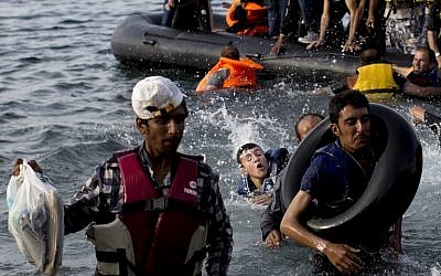 Migrants arrive on the shores of the Greek island of Lesbos after crossing the Aegean Sea from Turkey on a dinghy on September 9, 2015. (AFP / ANGELOS TZORTZINIS)