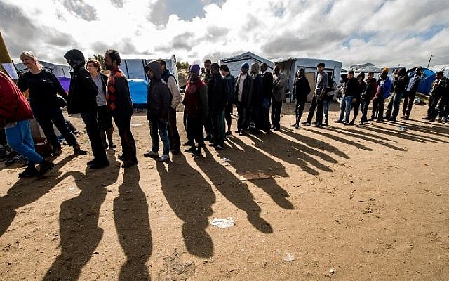 Migrants line up to get food at a site dubbed the "New Jungle", where some 3,000 people have set up camp -- most seeking desperately to get to England, in Calais, France on September 19, 2015. (AFP/ PHILIPPE HUGUEN)