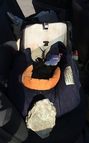 A rock on a car seat in a car that was damaged by stone-throwers south of Jerusalem on September 20, 2015. (Courtesy)