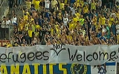 Fans of Maccabi Tel Aviv hold a banner with the text 'Refugees not welcome' during a match against Kiryat Shmona, on Saturday, September 12, 2015. (Screen capture: Channel 1)