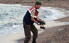 A paramilitary police officer carries the lifeless body of Aylan Kurdi, 3, after a number of migrants died and a smaller number were reported missing after boats carrying them to the Greek island of Kos capsized, near the Turkish resort of Bodrum early Wednesday, September 2, 2015. (AP/DHA)