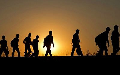 A group of refugees walk on the railway tracks after crossing from Serbia, in Roszke, Hungary, Tuesday, Sept. 1, 2015. (AP Photo/Darko Bandic)