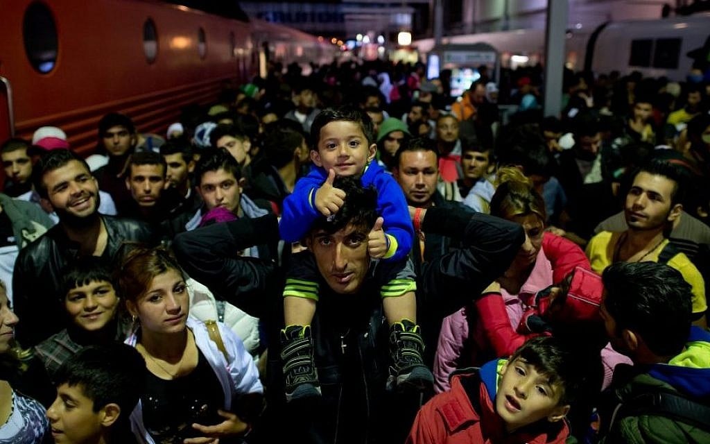 File: Refugees who arrived by train from Salzburg, Austria, wait on a platform at the central station in Munich, Germany, on September 6, 2015. (Photo by Sven Hoppe/dpa via AP) File: Refugees who arrived by train from Salzburg, Austria, wait on a platform at the central station in Munich, Germany, on September 6, 2015. (Photo by Sven Hoppe/dpa via AP)