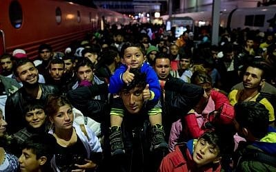 File: Refugees who arrived by train from Salzburg, Austria, wait on a platform at the central station in Munich, Germany, on September 6, 2015. (Photo by Sven Hoppe/dpa via AP)