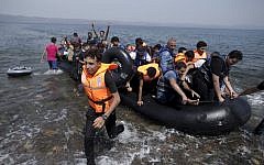 Syrians arrive on a dinghy after crossing from Turkey, at the Greek island of Lesbos, Monday, September 7, 2015. (Petros Giannakouris/AP)