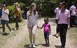 Clinton Foundation Vice Chair Chelsea Clinton walks with Theresa Balde, 5, while she talks with a Chakipi Distribution Enterprise worker during a visit at the Acceso Peanut Enterprise Corporation and Chakipi Distribution Enterprise, in Mirebalais, Haiti, Wednesday, July 29, 2015. (Dieu Nalio Chery/AP)