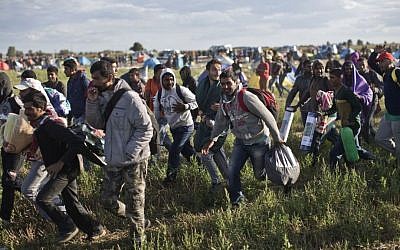 Migrants move away from a temporary holding center controlled by Hungarian authorities in Roszke, southern Hungary, Monday, September 7, 2015, inside Hungary, just over the border from Serbia. (Marko Drobnjakovic/AP)