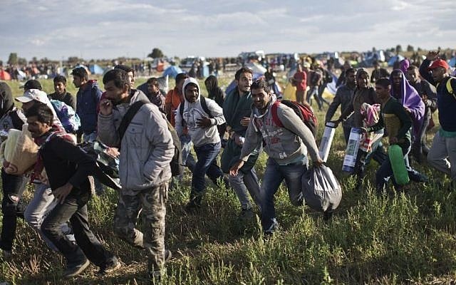 Migrants move away from a temporary holding center controlled by Hungarian authorities in Roszke, southern Hungary, Monday, September 7, 2015, inside Hungary, just over the border from Serbia. (Marko Drobnjakovic/AP) Migrants move away from a temporary holding center controlled by Hungarian authorities in Roszke, southern Hungary, Monday, September 7, 2015, inside Hungary, just over the border from Serbia. (Marko Drobnjakovic/AP)