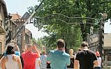 Tourists at Auschwitz photographing the 'Arbeit Macht Frei' gate, July 2015. (Ruth Ellen Gruber/JTA)