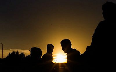 Refugees queue up for a bus, as they arrive at the border between Austria and Hungary, Heiligenkreuz, Austria, late Tuesday Sept. 15, 2015. (AP Photo/Christian Bruna)
