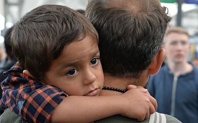 A young migrant boy sits on the shoulders of a man as they arrive at the Hauptbahnhof station in Salzburg, Austria, Saturday, Sept. 5, 2015 on their way from Hungary via Vienna to Germany. (AP Photo/Kerstin Joensson)