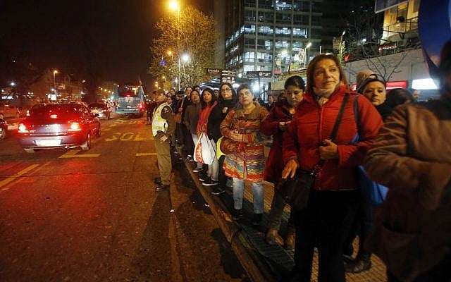 A police officer stands in the street to flag down buses for people to take home after an earthquake in Santiago, Chile, Wednesday, Sept. 16, 2015. (AP Photo/Luis Hidalgo) A police officer stands in the street to flag down buses for people to take home after an earthquake in Santiago, Chile, Wednesday, Sept. 16, 2015. (AP Photo/Luis Hidalgo)