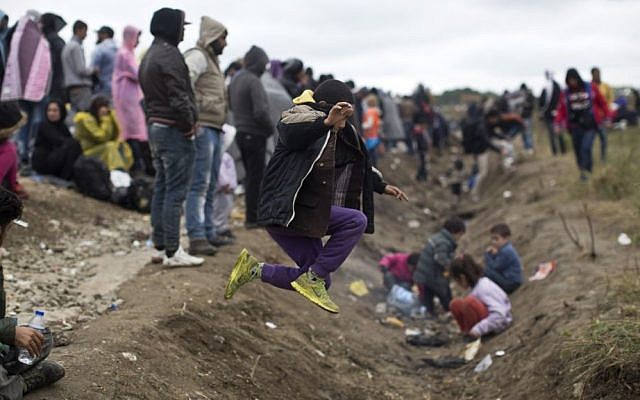 A child jumps over a ditch as people wait in order to clear a police line after entering Croatia from Serbia in Strosinci, Croatia, Saturday, Sept. 26, 2015 (AP Photo/Marko Drobnjakovic) A child jumps over a ditch as people wait in order to clear a police line after entering Croatia from Serbia in Strosinci, Croatia, Saturday, Sept. 26, 2015 (AP Photo/Marko Drobnjakovic)