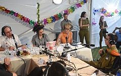 Defense Minister Moshe Ya'alon (left, in white shirt) being interviewed by Army Radio ahead of the Sukkot holiday, in the Defense Ministry's sukka in Tel Aviv. (Diana Hananshvili/Defense Ministry)