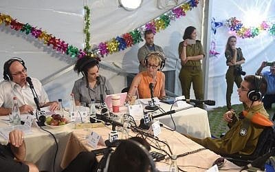 Defense Minister Moshe Ya'alon (left, in white shirt) being interviewed by Army Radio ahead of the Sukkot holiday, in the Defense Ministry's sukka in Tel Aviv. (Diana Hananshvili/Defense Ministry)