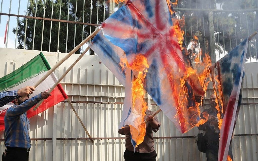 Iranians burn American, British and Israeli flags during the inauguration of an anti-American plaque displayed outside the former American embassy in Tehran on September 2, 2015. (Atta Kenare /AFP)