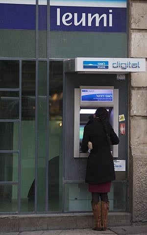 A woman stands at an ATM machine in Jerusalem (Photo credit: Yonatan Sindel/Flash90)