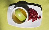 Apple in honey and pomegranate, traditionally eaten during Rosh Hashanah (Noam Revkin Fenton/ Flash90)