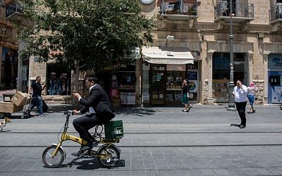 A man rides his bicycle along the train tracks on Jaffa Street in downtown Jerusalem, on June 24, 2015. (Yonatan Sindel/Flash90)