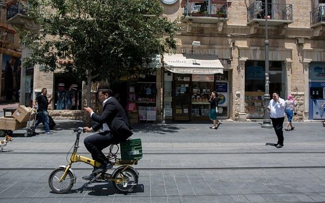 A man rides his bicycle along the train tracks on Jaffa Street in downtown Jerusalem, on June 24, 2015. (Yonatan Sindel/Flash90) A man rides his bicycle along the train tracks on Jaffa Street in downtown Jerusalem, on June 24, 2015. (Yonatan Sindel/Flash90)