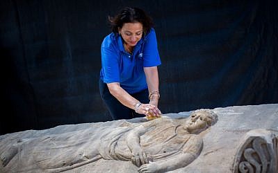 As Israeli antiquities authority worker cleans an 1,800 year-old stone sarcophagus outside the Israeli antiquities authority storage facility in Beit Shemesh on September 3, 2015 (Photo by Yonatan Sindel/Flash90)