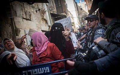 Palestinian Muslim women from the Murabitun group shout slogans and hold the Koran during a protest against Israel policemen preventing them from entering the Temple Mount compound in Jerusalem's Old City on September 17, 2015. (Miriam Alster/Flash90 )