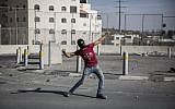 Illustrative photo of a Palestinian throwing a rock at Israeli Border Police during clashes in East Jerusalem on September 18, 2015. (Hadas Parush/Flash90/File)