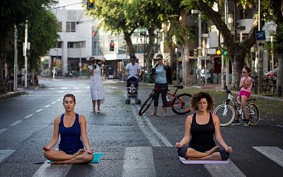 Israelis do yoga on an empty Tel Aviv street, on Yom Kippur, on September 23 2015. (Miriam Alster/Flash 90)