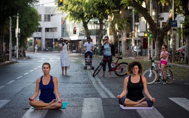 Israelis do yoga on an empty Tel Aviv street, on Yom Kippur, on September 23 2015. (Miriam Alster/Flash 90)