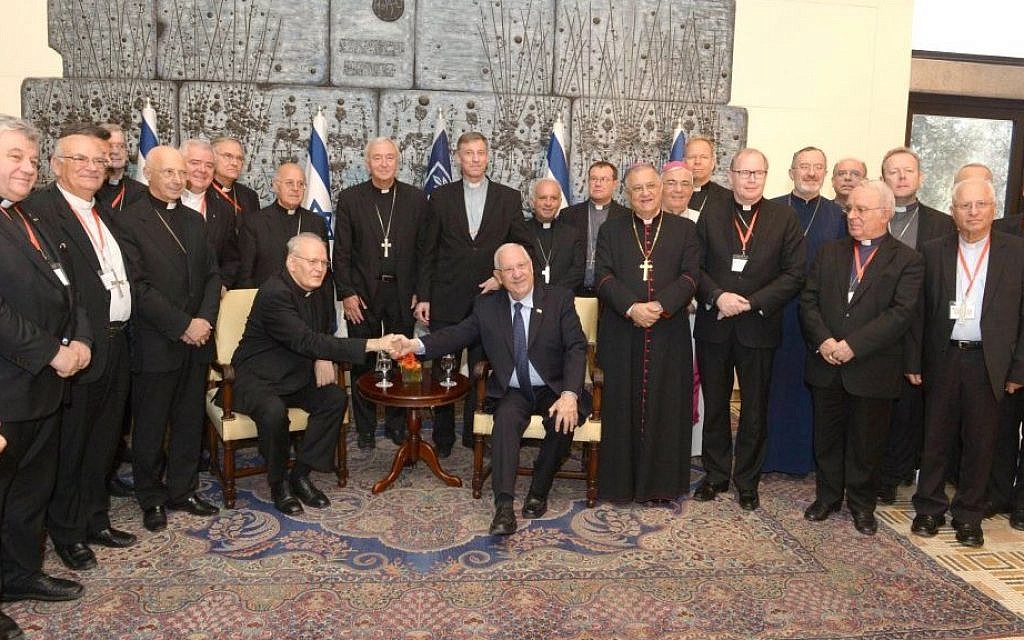 President Reuven Rivlin (sitting, center right) at his residence with members of the Council of the Bishops' Conferences of Europe, shakes hands with the president of the council Cardinal Péter Erdő, in Jerusalem, September 16, 2015. (Michael Nyman/GPO)